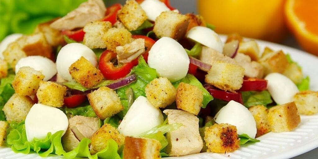 Салат з куркою, болгарським перцем, моцарелою, сухариками і мандариновою заправкою